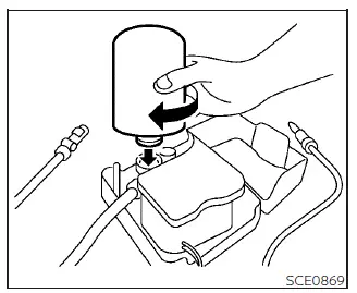 Installing the sealant bottle into the Nissan Leaf air compressor holder